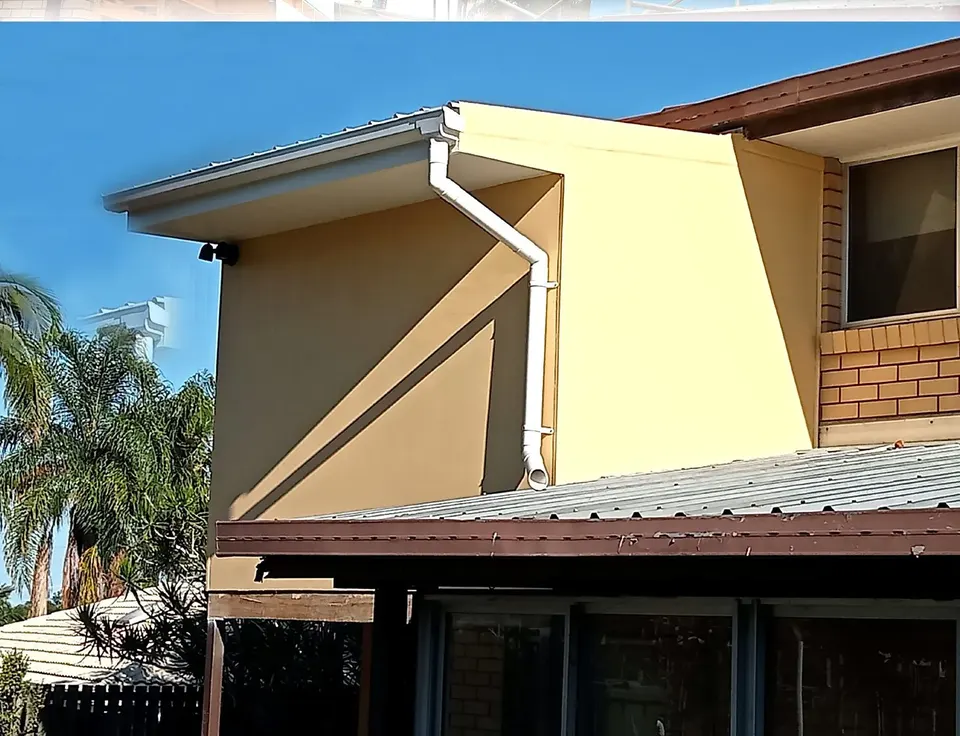 new guttering and downpipe fitted along a two-storey roofline